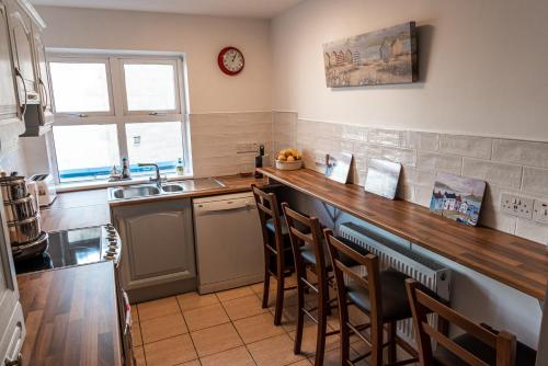 a kitchen with a counter with chairs and a sink at Seawinds Bed and Breakfast in Killybegs