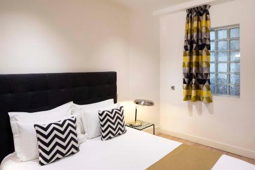 パリにあるAppartement rue de Rennes - Gaîtéのベッドルーム1室(ベッド1台、白黒の枕付)