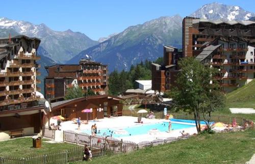 a large swimming pool in a resort with buildings at La Tania La Saboia sleep 8 private Sauna lounge dining 2 bathrooms kitchen 2 balconies ski in out in La Tania