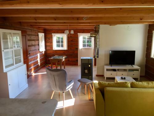 a living room with a couch and a tv at Roubenka Ella in Desná
