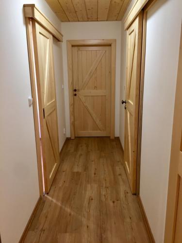 an empty hallway with a door and wooden floors at Roubenka Ella in Desná