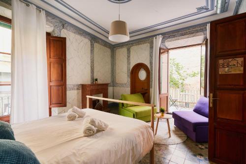 a bedroom with a bed and a chair and a window at Hostel Sóller in Sóller