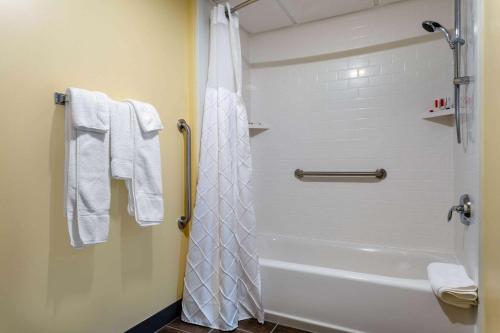 a bathroom with a shower with a white shower curtain at Days Inn by Wyndham Augusta in Augusta