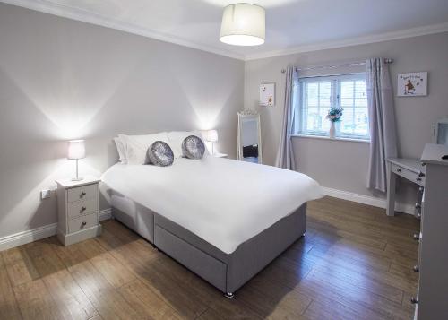 Un dormitorio con una gran cama blanca y una ventana en Host & Stay - Lowcross Cottage, en Guisborough