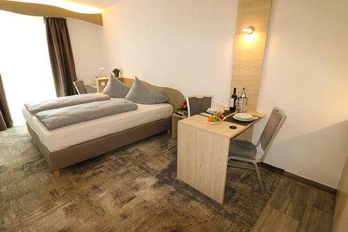 Schlafzimmer mit einem Bett und einem Tisch sowie einem Tisch und Stühlen in der Unterkunft Petul Apart Hotel An'ne 40 in Bochum