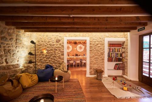 a living room with a couch and a stone wall at Hostel Sóller in Sóller