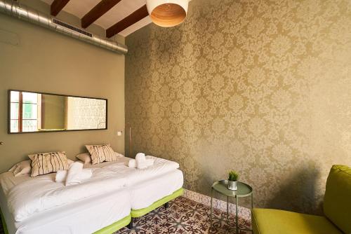 a room with a white bed with a mirror on the wall at Hostel Sóller in Sóller