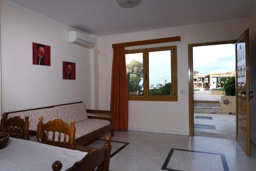 a living room with a couch and a window at Esperides Beach Hotel Apartments in Stalos