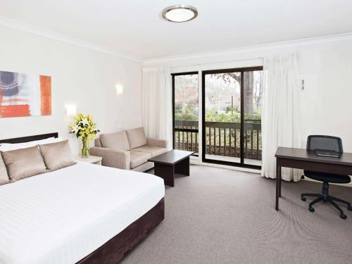 a hotel room with a bed and a desk and a computer at Tall Trees Ainslie Motel in Canberra