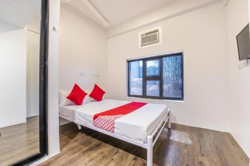 a bedroom with a bed with red pillows and a window at OYO 563 Mytown New York in Manila