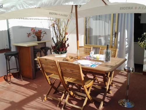 una mesa de madera y sillas bajo una sombrilla en La Terraza, en Vinarós