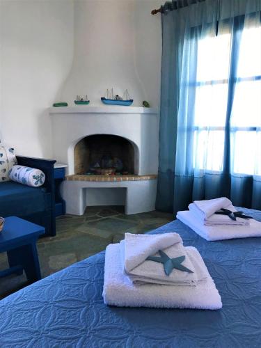 a bedroom with a bed with towels and a fireplace at Cavos Studio by the sea in Drios