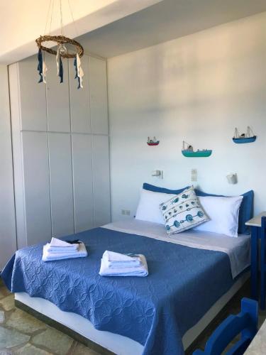 a bedroom with a blue bed with towels on it at Cavos Studio by the sea in Drios