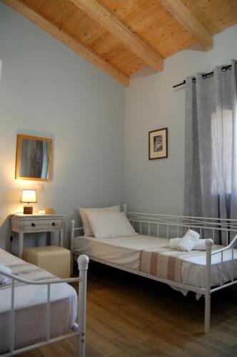 a bedroom with two beds and a window at Blue Lagoon Villa in Poros