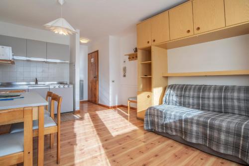 uma cozinha e uma sala de estar com uma cama e uma mesa em Alpine Smart Residence em Folgaria
