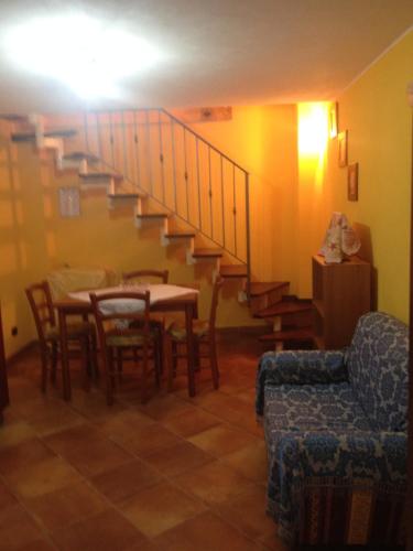 a living room with a table and a staircase at Basicò un balcone sul mare - Casa SALITA FOTI -Case vacanza Sicilia&Toscana- in Basicò