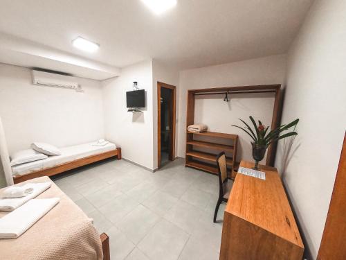 a room with a bedroom with a desk and a bed at Amarilis Pousada Arraial d'Ajuda in Arraial d'Ajuda