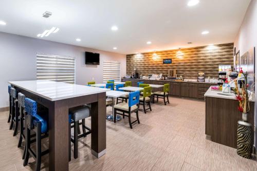 a restaurant with tables and chairs and a kitchen at Clarion Pointe Madison-Huntsville in Madison