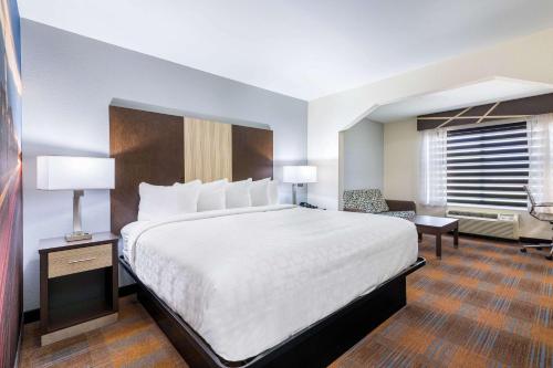 a hotel room with a large bed and a desk at Clarion Pointe Madison-Huntsville in Madison