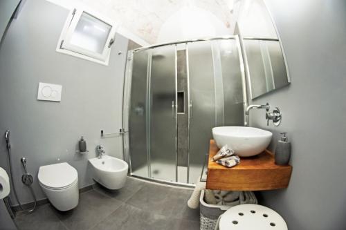 uma casa de banho com um chuveiro, um lavatório e um WC. em Elaion Home em Ostuni