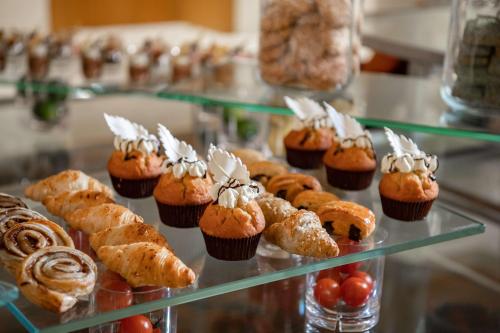 a display case filled with cupcakes and other pastries at Radisson Blu Hotel & Residence, Riyadh Diplomatic Quarter in Riyadh