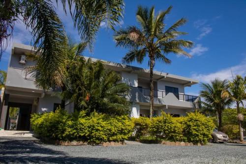 a building with palm trees in front of it at Pousada Morada da Praia - Balneário Camboriú in Balneário Camboriú