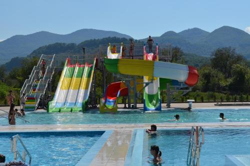 people in a swimming pool with a water park at Tulipan Hotel Aquapark in Vyshkove