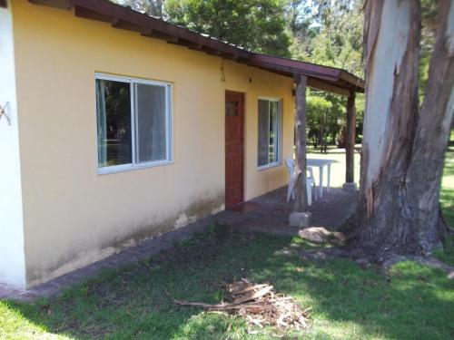 a small yellow house with a tree next to it at La Posada del Mar in Miramar