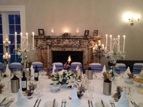 a table set up for a wedding with a fireplace at Otterburn Castle in Newcastle upon Tyne