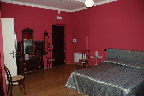 a bedroom with red walls and a bed and chairs at Zia Carmela in Montella