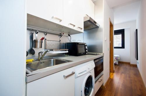 a kitchen with a sink and a washing machine at Charming Madrid Urgel in Madrid