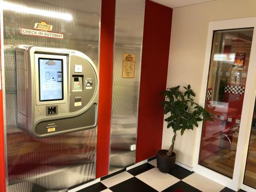 uma máquina de multibanco numa sala com um vaso de plantas em Jukebox Hotel em Znojmo