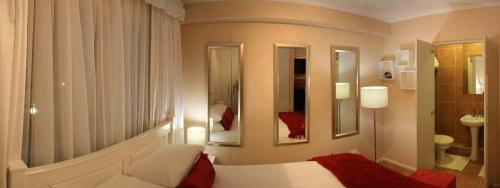 Habitación de hotel con cama y baño en La Loggia Gateway Apartments en Durban