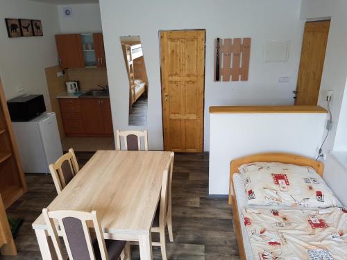 Zimmer mit einem Tisch und Stühlen sowie einer Küche in der Unterkunft Autocamp Slunce Žandov in Žandov