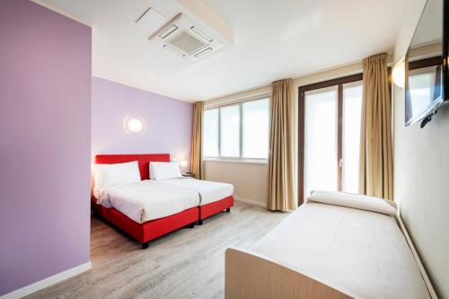 a hotel room with two beds and a window at Residence Lenno in Lenno