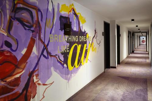 a hallway with a painting on the wall at Holiday Inn - the niu, Air Frankfurt Messe by IHG in Frankfurt/Main
