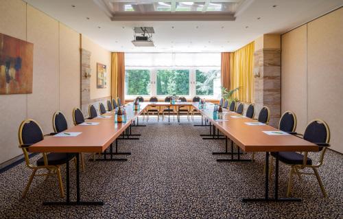 a conference room with long tables and chairs at Parkhotel am Taunus in Oberursel
