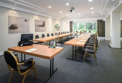 a row of tables and chairs in a room at Parkhotel am Taunus in Oberursel