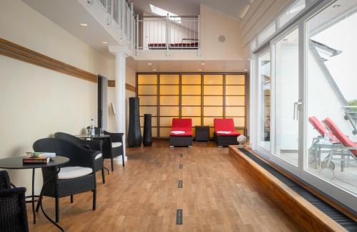 a lobby with red chairs and tables in a building at Parkhotel am Taunus in Oberursel