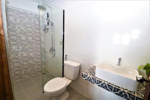 a bathroom with a toilet and a sink and a shower at Grand Elevation Hotel in Phnom Penh