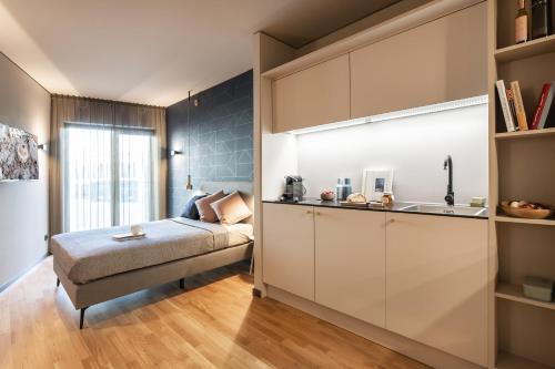 um quarto com uma cama e uma cozinha com um lavatório em ipartment Frankfurt Airport em Frankfurt