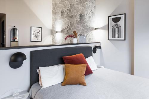 a bedroom with a bed with orange and white pillows at ipartment Frankfurt Airport in Frankfurt/Main