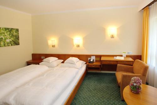 a hotel room with two beds and a desk at Parkhotel am Taunus in Oberursel