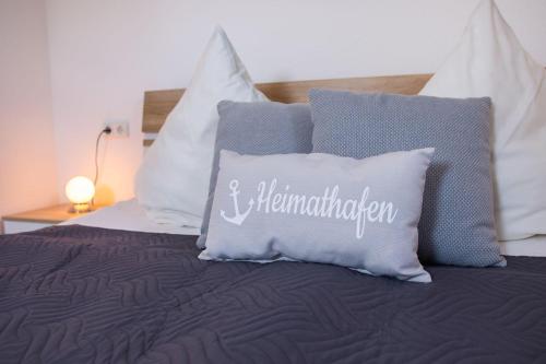 a bed with white pillows and a bed with at Haus Strandburg Seebriese in Dahme