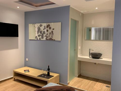 a living room with a table and a sink at Evdokia Suites in Gouves