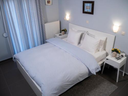 1 dormitorio con 1 cama con sábanas y almohadas blancas en Central Terrace Modern Apartment, en Tesalónica