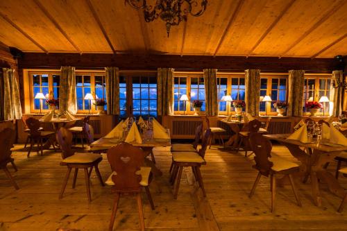 ein Esszimmer mit Tischen, Stühlen und Fenstern in der Unterkunft Freihaus Brenner in Bad Wiessee