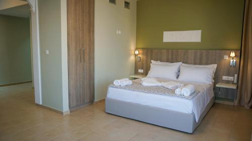 a bedroom with a bed with towels on it at Agnes Deluxe Hotel in Pefkohori