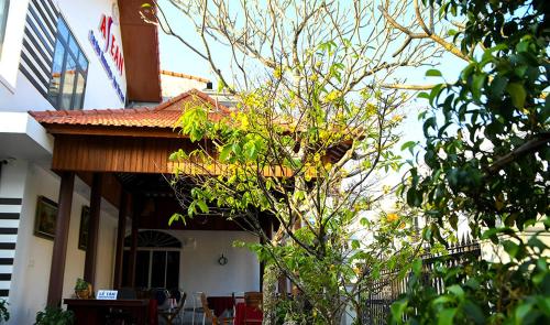 a building with a porch with tables and chairs at Asean Garden Homestay Hue in Hue