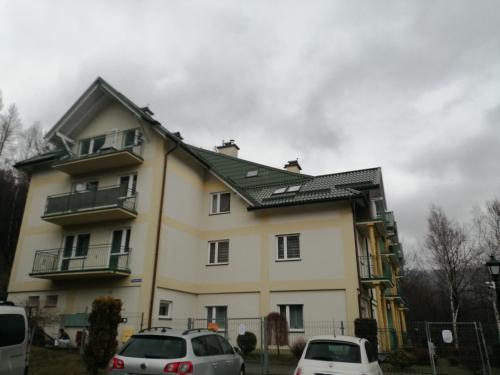 una casa con dos coches estacionados frente a ella en Apartament Równica, en Ustroń